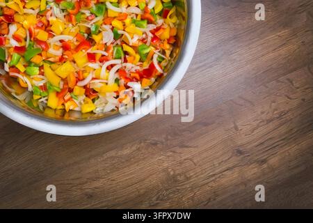Colored pepper and onion are sliced in a bowl. salad for the winter. conservation Stock Photo