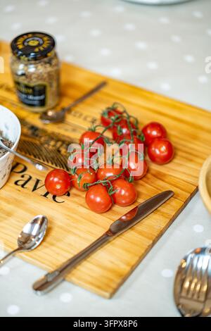 Cherry tomatoes on the vine on a wooden board laid out for a shoot lunch at a shooting lodge in Glen Clova, Angus, Scotland Stock Photo