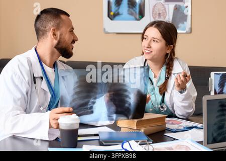 Medical collaboration and diagnosis, doctors discussing patient x-ray results in hospital office with teamwork and professional healthcare communicati Stock Photo