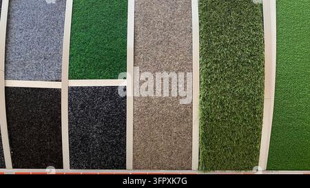 Assorted carpet and artificial grass flooring samples in different colors and textures displayed at home improvement store Stock Photo