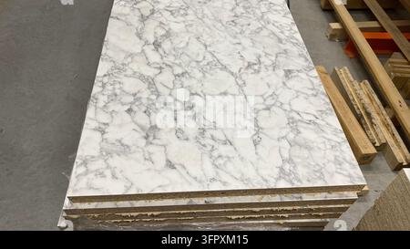 Stack of laminated particle boards with white marble pattern and gray veining displayed at home improvement store Stock Photo