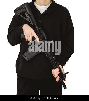 Man in black holding AR-15 tactical rifle across chest isolated on white background Stock Photo