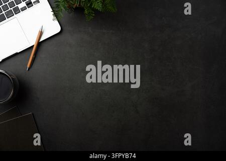 Top view of dark stone desk background with laptop, notebook and office supplies with large copy space Stock Photo
