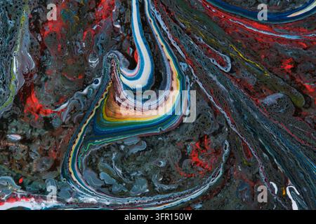 Moody abstract fluid art with dark textured background and central colorful paint swirl Stock Photo