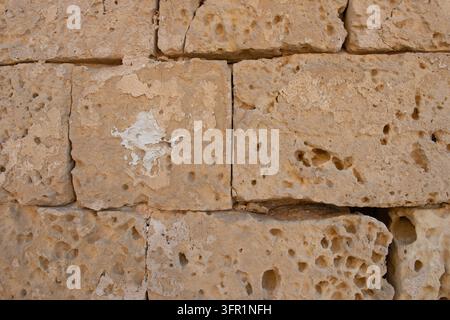 Weathered porous limestone masonry blocks with white plaster trace in Malta. Stock Photo