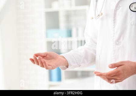 Healthcare consultation and medical advice, doctor with open hands offering support and professional guidance in a clinic or hospital office setting Stock Photo