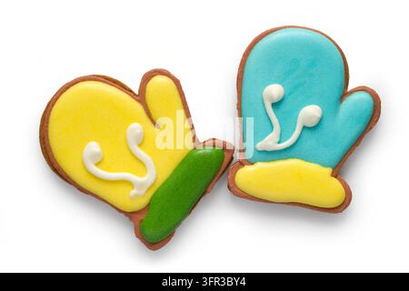 Christmas gingerbread in the form of a pair of mittens. Glazed Christmas cookies isolated on white background. Stock Photo