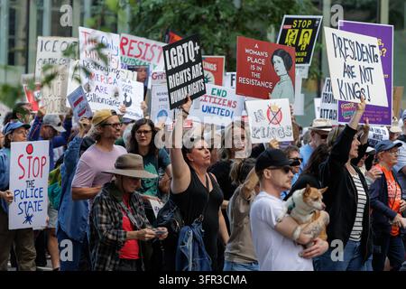 Minneapolis, Minnesota, USA - July 17, 2025: Crowd marches through downtown waving LGBTQ, "No Kings" and diverse protest signs at anti-Trump rally. Stock Photo