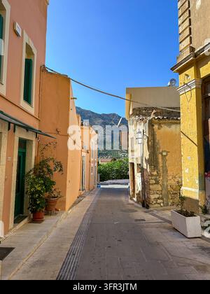 Crete,Greece - August 28, 2026:Quiet Mediterranean old town street lined with pastel facades, weathered stone buildings, and traditional architecture Stock Photo