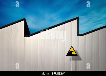 Composition of a wave-shaped façade that aligns with a wavy pattern in a blue sky. Stock Photo