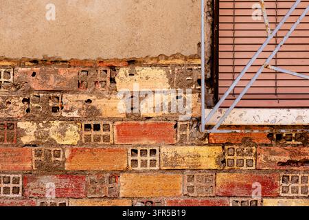 Rough wall displays a pattern of bricks with different colors and ...
