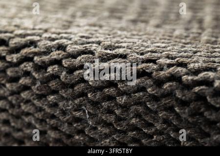 Brown knitted fabric shows a detailed texture and weaving pattern. The soft surface creates an abstract background Stock Photo