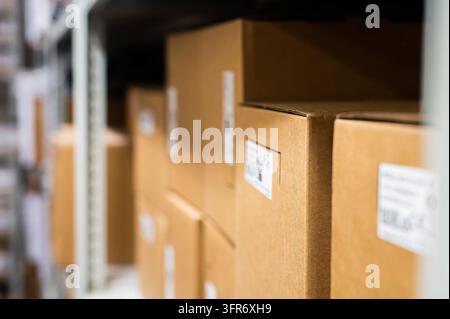 Warehouse goods. Rows of shelves with goods in cardboard boxes, close-up Stock Photo