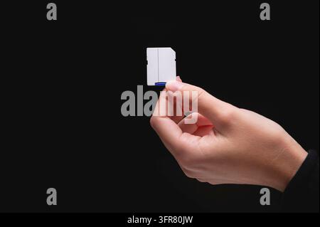 New fast micro SD memory cards and SD card adapter in hand on black background Stock Photo