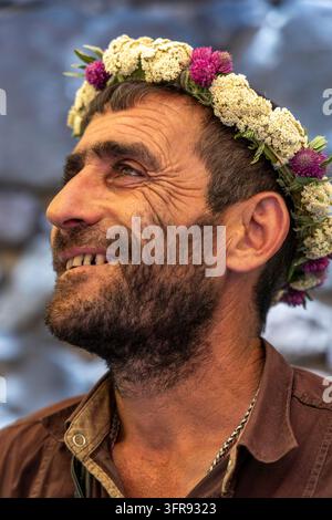 Portrait of a man wearing a flower crown of yarrow and clover looking upward in profile, Kotayk Province, Geghard, Armenia Stock Photo
