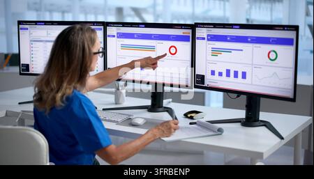 Healthcare Manager Carefully Reviews Electronic Medical Claims On Computer Screen. Stock Photo