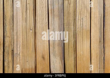 Natural wooden background made of vertical weathered planks with visible grain and rough texture, rustic timber surface with warm brown tones and Stock Photo