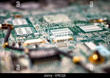 Close up of a green printed circuit board with electronic connectors, solder contacts and intricate circuitry. Macro technology background with select Stock Photo