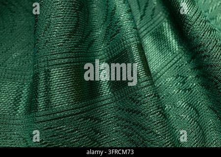 Dark Green Textured Fabric with Draped Folds and Subtle Checkered Pattern, Textile Background Stock Photo
