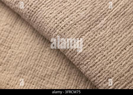 Beige Knitted Fabric Texture with Overlapping Layers, Close-Up Textile Background Stock Photo