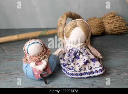 Traditional Ukrainian Motanka Dolls in Embroidered Folk Dresses with Wheat on Rustic Wooden Table Stock Photo