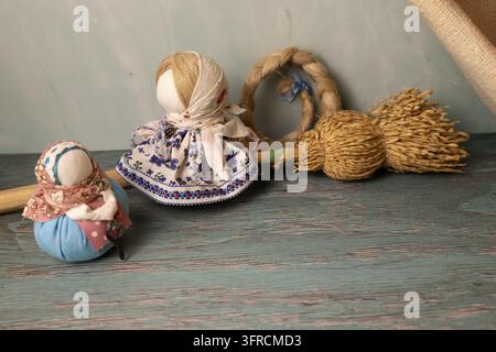 Traditional Handmade Folk Dolls and Wheat Sheaf on Rustic Wooden Table Stock Photo
