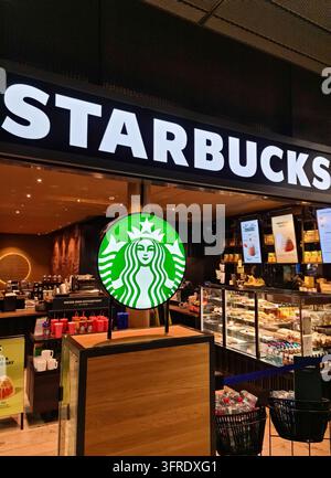Keflavik, Iceland - March 05, 2025: Illuminated Starbucks logo displayed at a coffee shop inside of Keflavik International Airport Terminal in Iceland Stock Photo