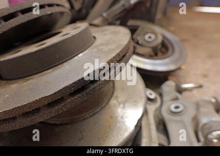 Discarded old automotive brake rotors displaying significant rust and wear from prolonged use, symbolizing vehicle maintenance, repair, and the need f Stock Photo