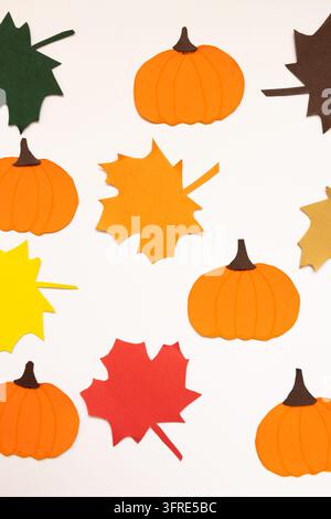 Paper pumpkins and leaves in fall tones on a white background, forming a colorful decorative design with a concept of crafts and seasonal decoration Stock Photo