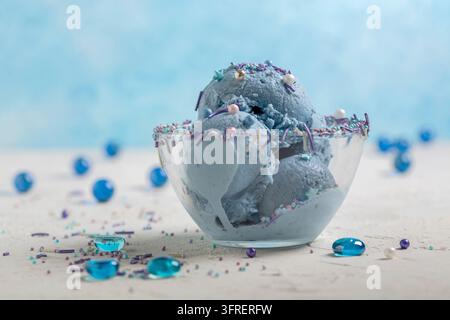 Homemade blue ice cream with anchan tea served with colorful sugar sprinkles, selective focus. Copy space. Concept of summer desserts Stock Photo
