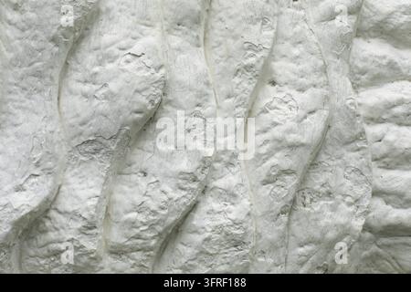 Texture is white. Sculpture details. White washed surface. Background is from lumps. Stone waves Stock Photo