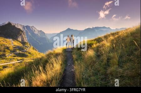 Women hikers with backpacks standing on trail in mountain valley Stock Photo