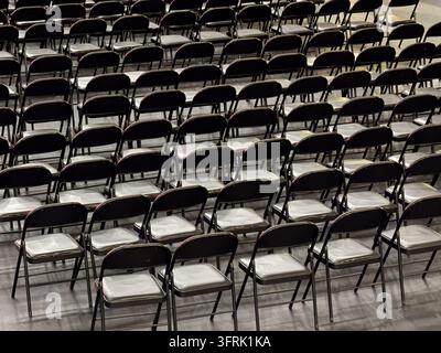 empty black folding chairs in rows at event hall, concept of conference, meeting, education, banner Stock Photo