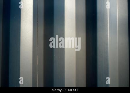 Vertical metal bars in dark blue and silver with light reflections. Stock Photo