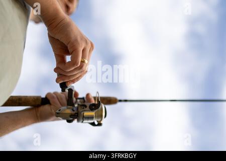 Low angle view of a man's hands on a fishing reel Stock Photo