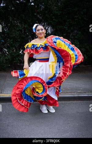 Prioe to the 2026 Hispanic Day Parade an attractive Columbian American woman spins her dress for a portrait. In Jackson heights, Queens, New York. Stock Photo