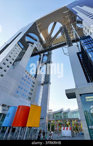 Low-angle view of the Floating Garden Observatory bridging two towers, with koinobori carp streamers above the plaza in late afternoon. Stock Photo