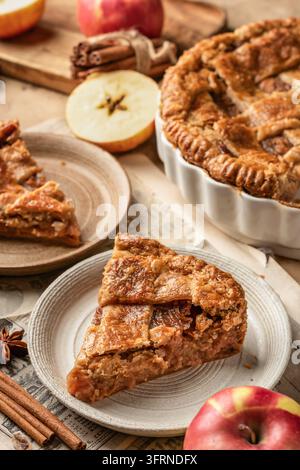 A piece of delicious crust Apple Pie with fresh apples on ceramic plate. Thanksgiving traditional dessert, autumn baking, recipe Stock Photo