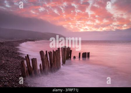 Weatherd wooden groyne at high tide on Bossington Beach during sunset, Exmoor National Park, Somerset, England.  Autumn (September) 2026. Stock Photo