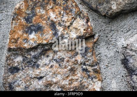 brown black and white textures on a wall surface featuring stone topography and texture Stock Photo