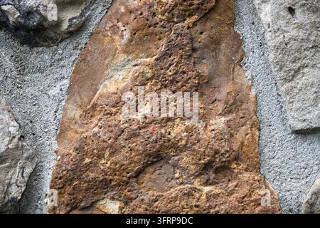 brown black and white textures on a wall surface featuring stone topography and texture Stock Photo