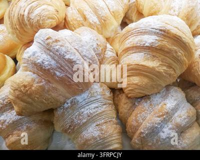 Fresh croissants filled with cream or jam in a bakery on a shelf ready for sale Stock Photo