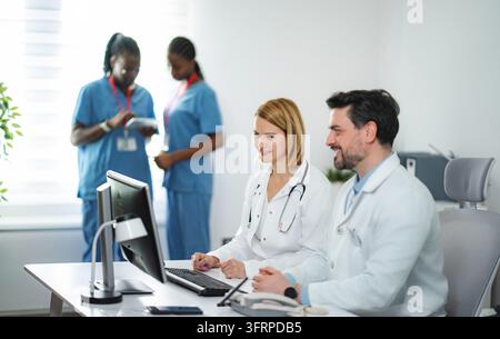 Medical professionals collaborating on computer in clinic office Stock Photo