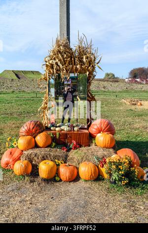 A creative self-portrait of a photographer reflected in an installation mirror at a pumpkin festival near Poltava, Ukraine. A unique rustic autumn sce Stock Photo
