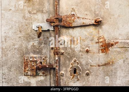 Rusty metal door with latch and padlock closing, creating a sense of security and privacy Stock Photo