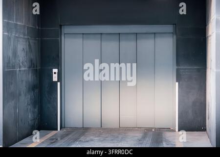 Metal cargo elevator in an industrial warehouse or parking facility, providing vertical transport for logistics and heavy goods Stock Photo