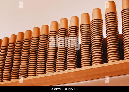 Rows of recycled brown paper cups neatly stacked on a wooden shelf, forming a repetitive and rhythmic pattern Stock Photo