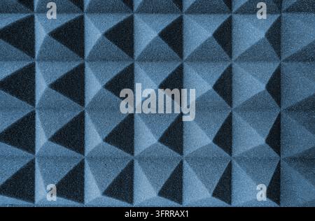 Acoustic foam panel with pyramid pattern in deep blue, ideal for recording studio or soundproofing backgrounds. Stock Photo