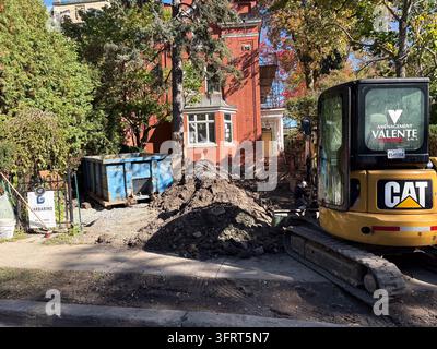 Construction work underway in Westmount, an affluent and historic residential enclave on the island of Montreal, Quebec, Canada, with an excavator and Stock Photo