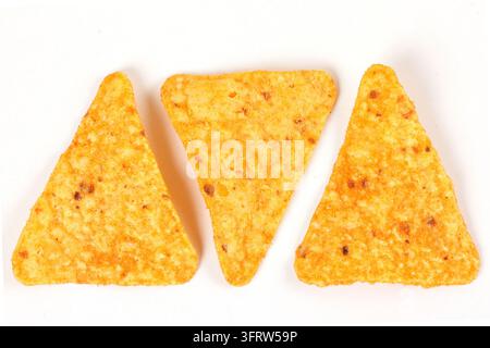 Three crispy baked triangular nacho tortilla chips isolated on a white background. Mexican cuisine. Top view Stock Photo